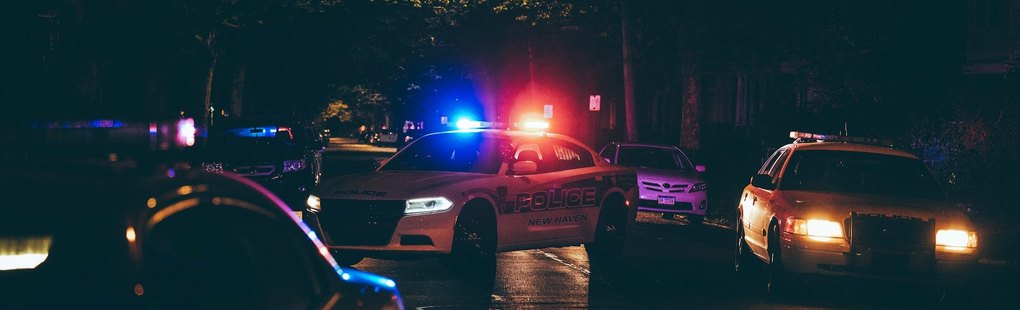 Patrol cars with light bars on a wet night street